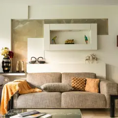 Beżowy salon aranżacje: sofa, fortepian, dekoracje, lampy. Ciepłe kolory i eleganckie dodatki tworzą przytulną atmosferę.
