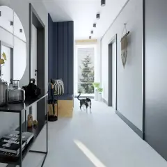 Okrągłe lustro w stylu loft nad konsolą z dekoracjami. Kot przechadza się po nowoczesnym korytarzu.