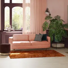 Elegancki salon z różową kanapą i miodowymi fotelami. Z jakim kolorem połączyć różowy? Zobacz, jak świetnie wygląda z brązem i fioletem.