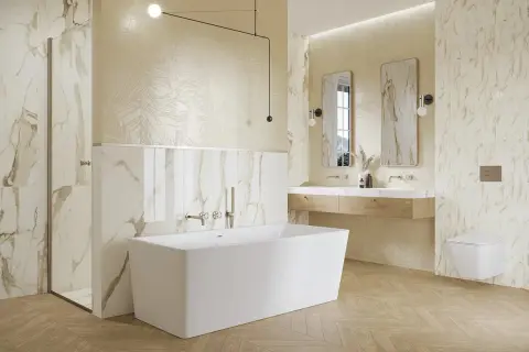 Elegancka łazienka ze złotymi dodatkami. Marmurowe płytki, wolnostojąca wanna i drewniana podłoga tworzą luksusową atmosferę.