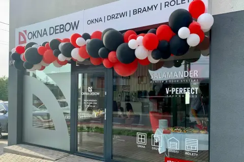 Salon okien i drzwi "Okna Dębow" z girlandą czerwonych, czarnych i białych balonów.