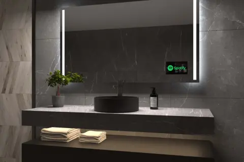 Nowoczesne lustro z telewizorem w łazience, wyświetlające Spotify.