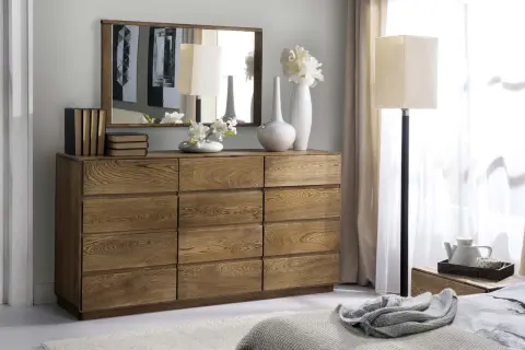 Drewniana komoda z lustrem, lampą i wazonami. Naturalne drewno tworzy ciepłą atmosferę.