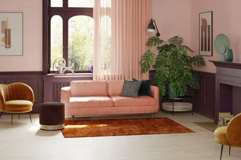 Elegancki salon z różową kanapą i miodowymi fotelami. Z jakim kolorem połączyć różowy? Zobacz, jak świetnie wygląda z brązem i fioletem.