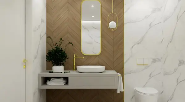 Elegancka łazienka z umywalką, złotą baterią i wiszącą toaletą. Centralnym punktem jest owalne lustro łazienkowe w złotej ramie, wiszące na drewnianej ścianie.