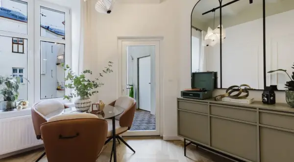 Eleganckie lustra w stylu retro nad komodą z gramofonem i książkami.