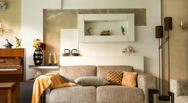 Beżowy salon aranżacje: sofa, fortepian, dekoracje, lampy. Ciepłe kolory i eleganckie dodatki tworzą przytulną atmosferę.