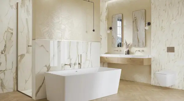 Elegancka łazienka ze złotymi dodatkami. Marmurowe płytki, wolnostojąca wanna i drewniana podłoga tworzą luksusową atmosferę.