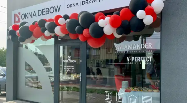 Salon okien i drzwi "Okna Dębow" z girlandą czerwonych, czarnych i białych balonów.
