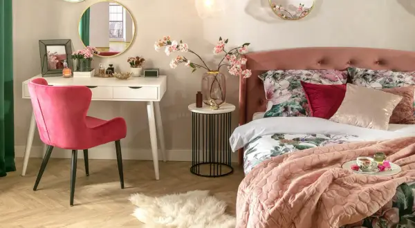 Elegancka toaletka w sypialni aranżacje: biała toaletka, różowe krzesło, lustra i kwiaty tworzą przytulną przestrzeń.