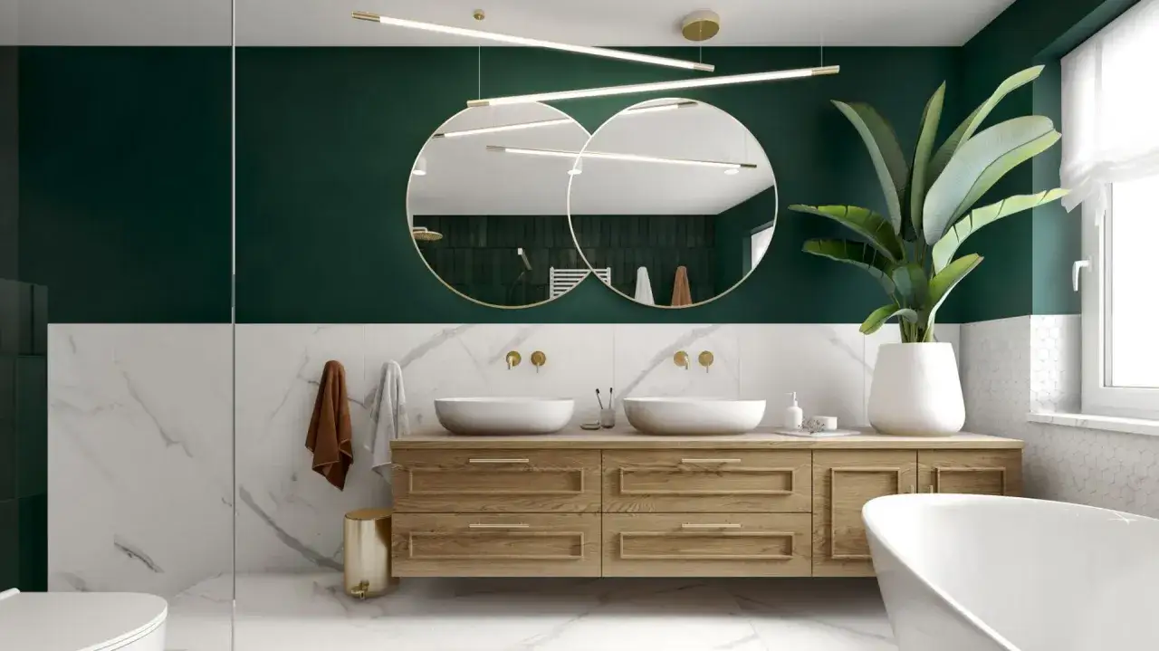 Elegancka łazienka z dwoma lustrami w złotych ramach, umieszczonymi nad drewnianą szafką z dwiema umywalkami.