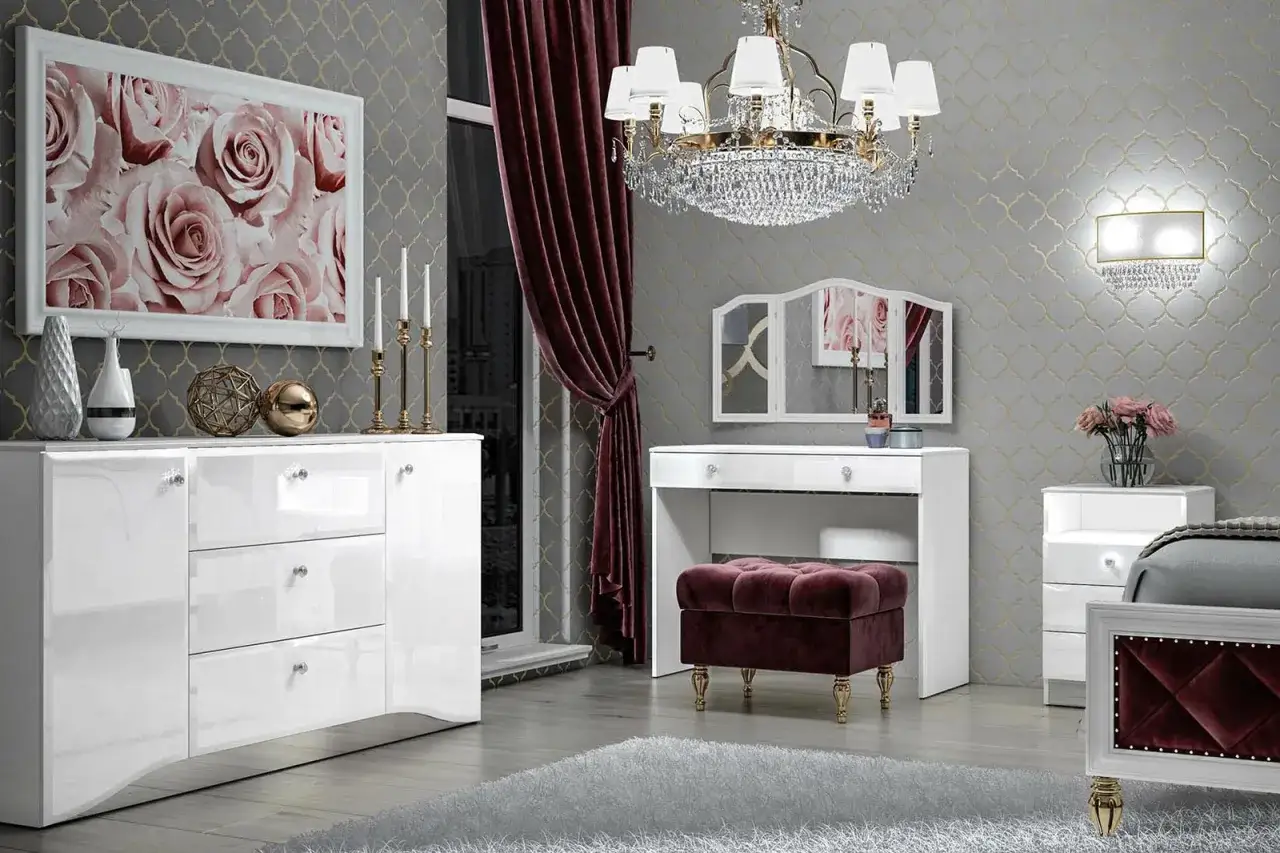 Elegancka sypialnia z toaletką inspiracje: białe meble, aksamitna pufa, kryształowy żyrandol i obraz z różami.