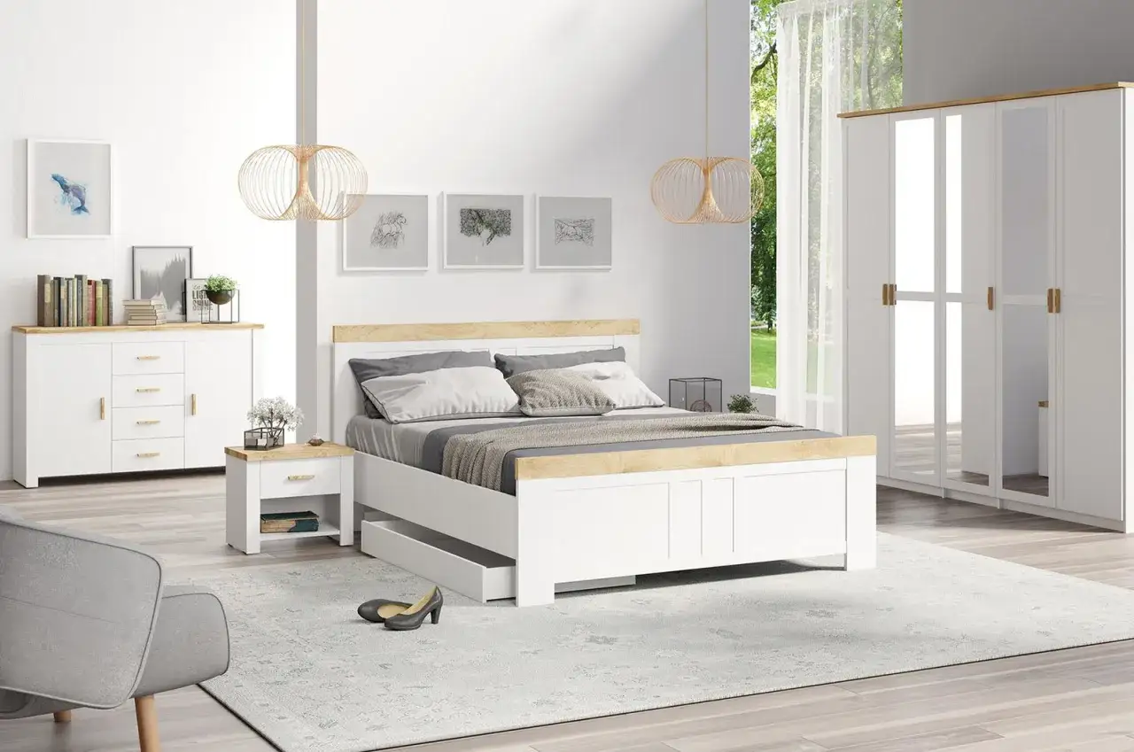 Sypialnia w stylu new hampton: białe łóżko z drewnianym zagłówkiem, szafki nocne, komoda, szafa z lustrami i szary fotel.