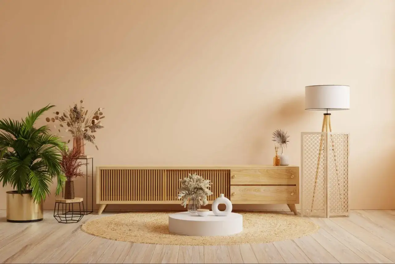 Salon w stylu boho. Jasne ściany, drewniana komoda, okrągły dywan i dekoracje w kolorach pasujących do beżu i brązu.