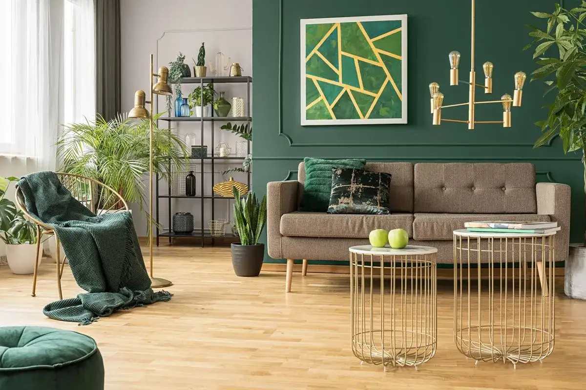 Beżowy salon aranżacje: stylowa kanapa, złote stoliki, zielone akcenty i rośliny tworzą przytulną atmosferę.