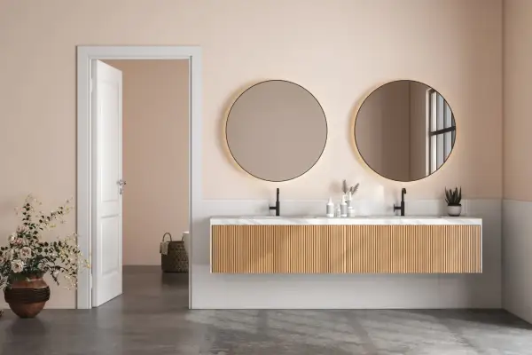 Elegancka łazienka z dwoma okrągłymi, podświetlanymi lustrami, które stanowią oryginalne lustra do łazienki.