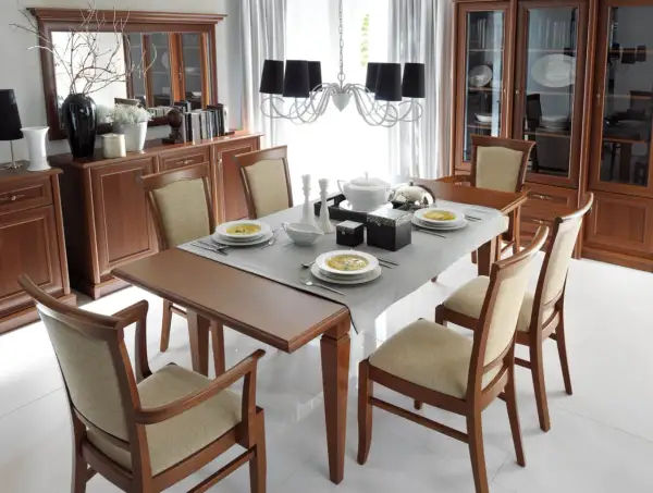 Elegancka jadalnia z drewnianymi meblami i dużym lustrem nad komodą. Inspiracje na stylowe wnętrze.